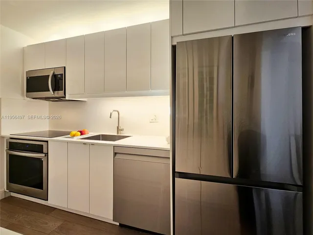 a kitchen with stainless steel appliances a refrigerator and a stove top oven