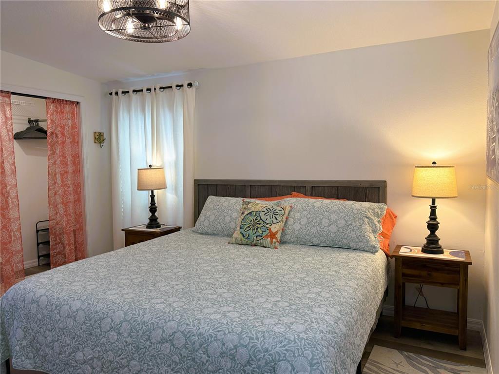 12507 Cortez Road West, Unit 19 Cortez, FL 34215 - Photo 11 of 31 a bedroom with a bed and a chandelier