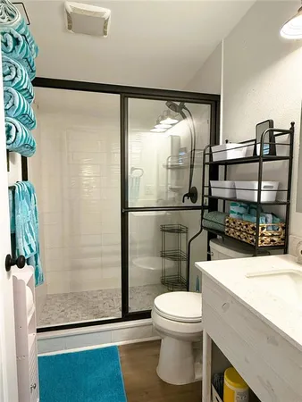 a bathroom with a sink a toilet and shower