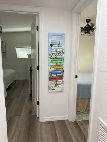 a view of a hallway with bathroom and wooden floor