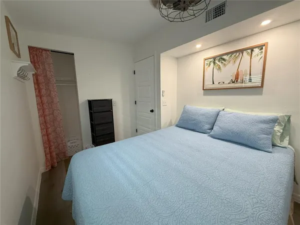 a bedroom with a bed and a painting on the wall