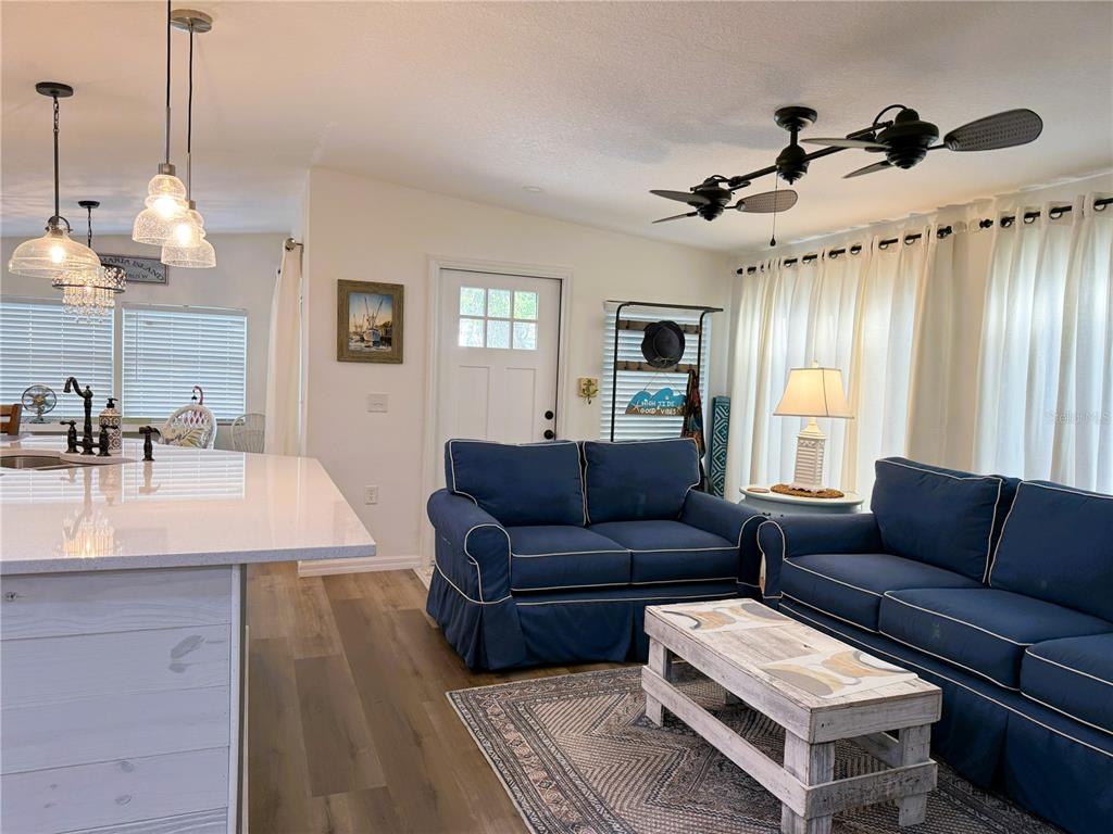 12507 Cortez Road West, Unit 19 Cortez, FL 34215 - Photo 7 of 31 a living room with furniture and a chandelier