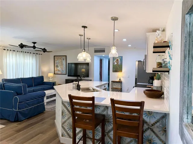 a view of a dining room and livingroom with furniture wooden floor a chandelier