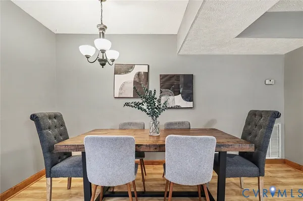 a view of a dining room with furniture and chandelier