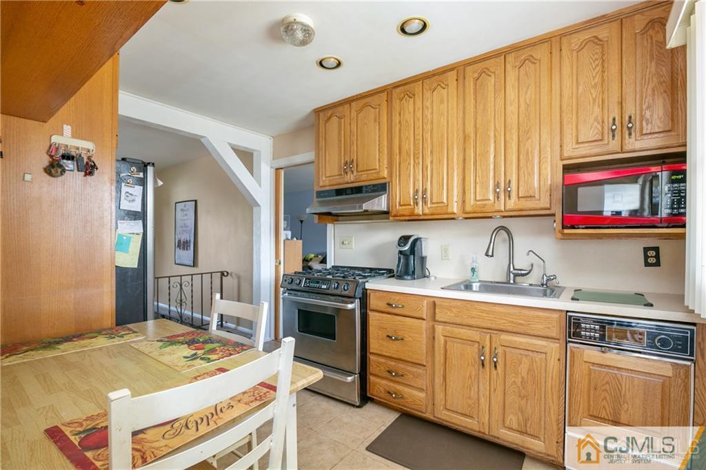 7 Columbia Road Old Bridge, NJ 08859 - Photo 13 of 25 a kitchen with stainless steel appliances granite countertop a stove a sink dishwasher and cabinets with wooden floor