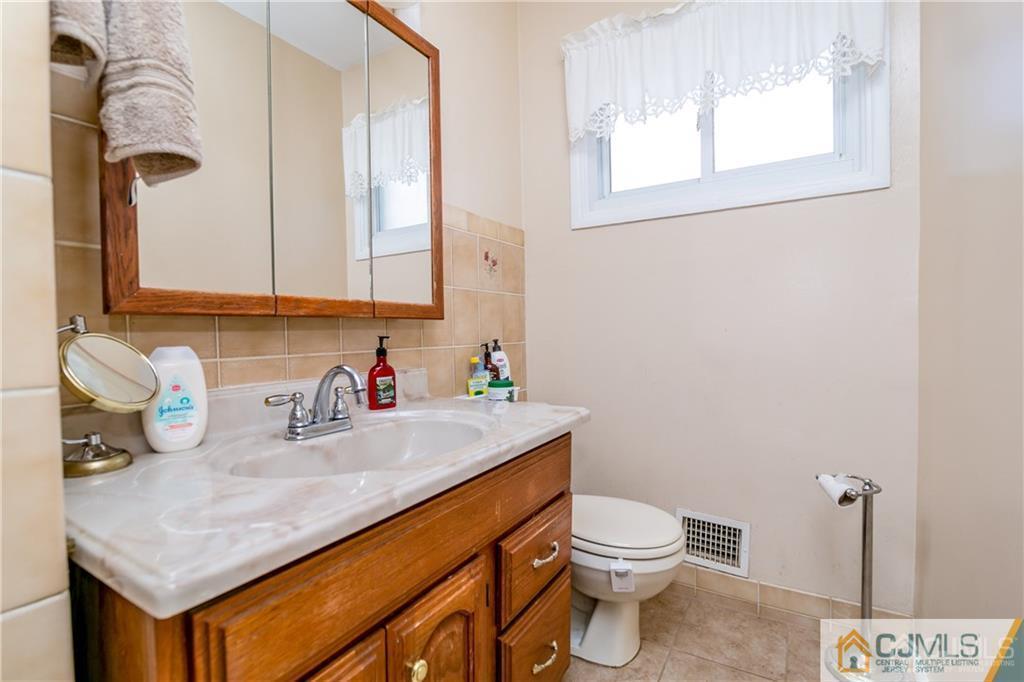 7 Columbia Road Old Bridge, NJ 08859 - Photo 15 of 25 a bathroom with a sink a toilet and mirror