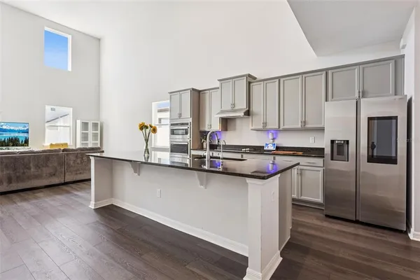 a kitchen with stainless steel appliances a sink a stove a refrigerator and cabinets