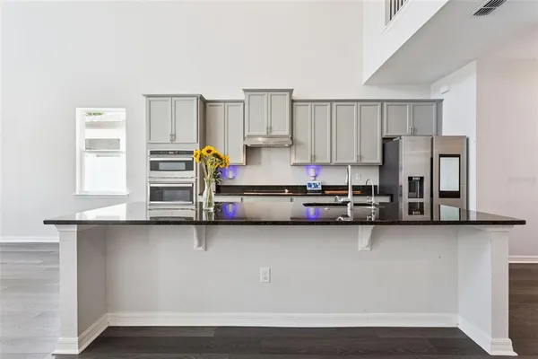 a view of kitchen with refrigerator stove and wooden cabinets