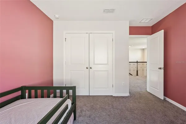 a spacious bedroom with a bed and a cabinets