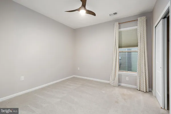 an empty room with closet and windows
