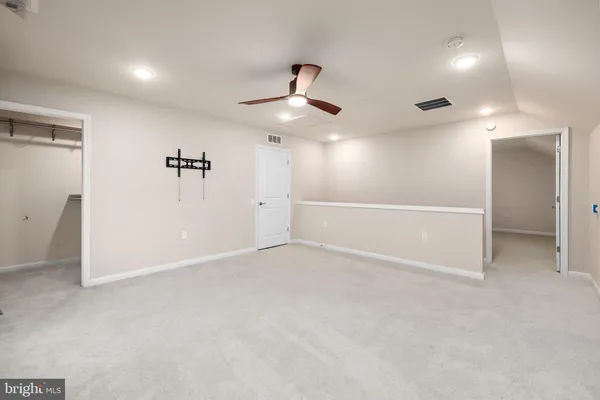 an empty room with closet and windows