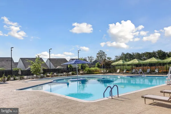 a view of a house with pool and chairs