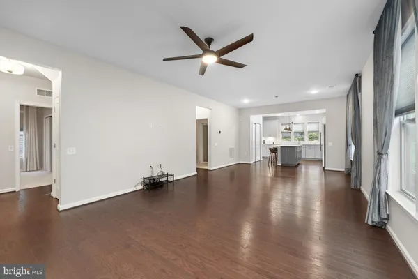 a view of empty room with wooden floor and ceiling fan