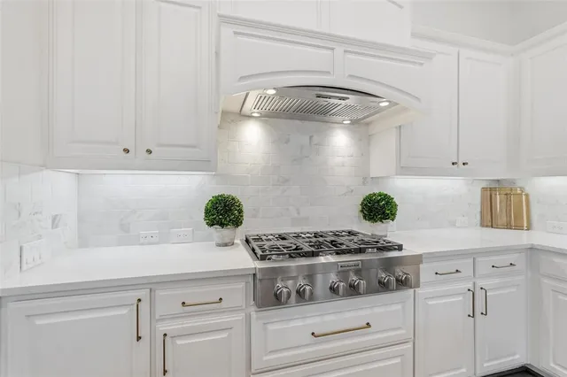 a kitchen with white cabinets and appliances