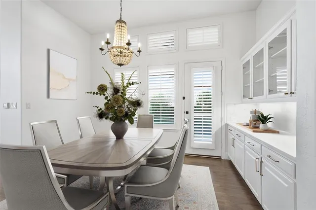 a dining room with furniture potted plants and wooden floor