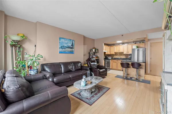 a kitchen with stainless steel appliances granite countertop a refrigerator a stove a sink dishwasher and white cabinets with wooden floor