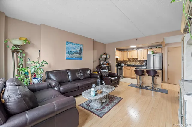 a kitchen with stainless steel appliances granite countertop a refrigerator a stove a sink dishwasher and white cabinets with wooden floor