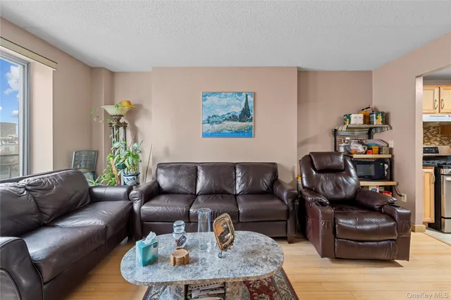 a living room with furniture a flat screen tv and a large window