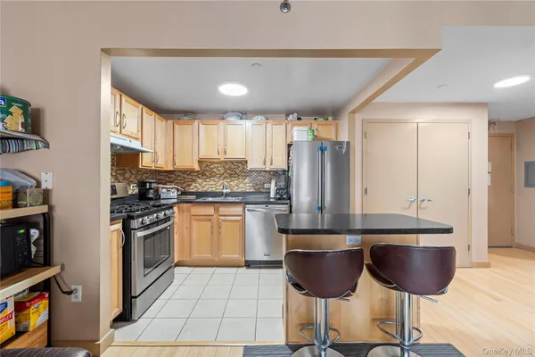 a kitchen with stainless steel appliances granite countertop a stove a sink and a refrigerator