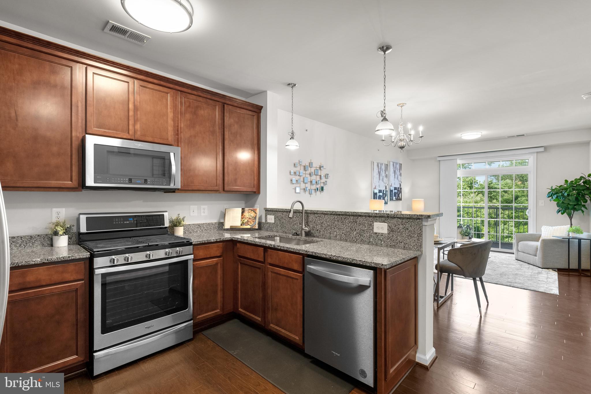 3835 Doc Berlin Drive, Unit 44 Silver Spring, MD 20906 - Photo 14 of 28 a kitchen with stainless steel appliances granite countertop wooden floors and stove