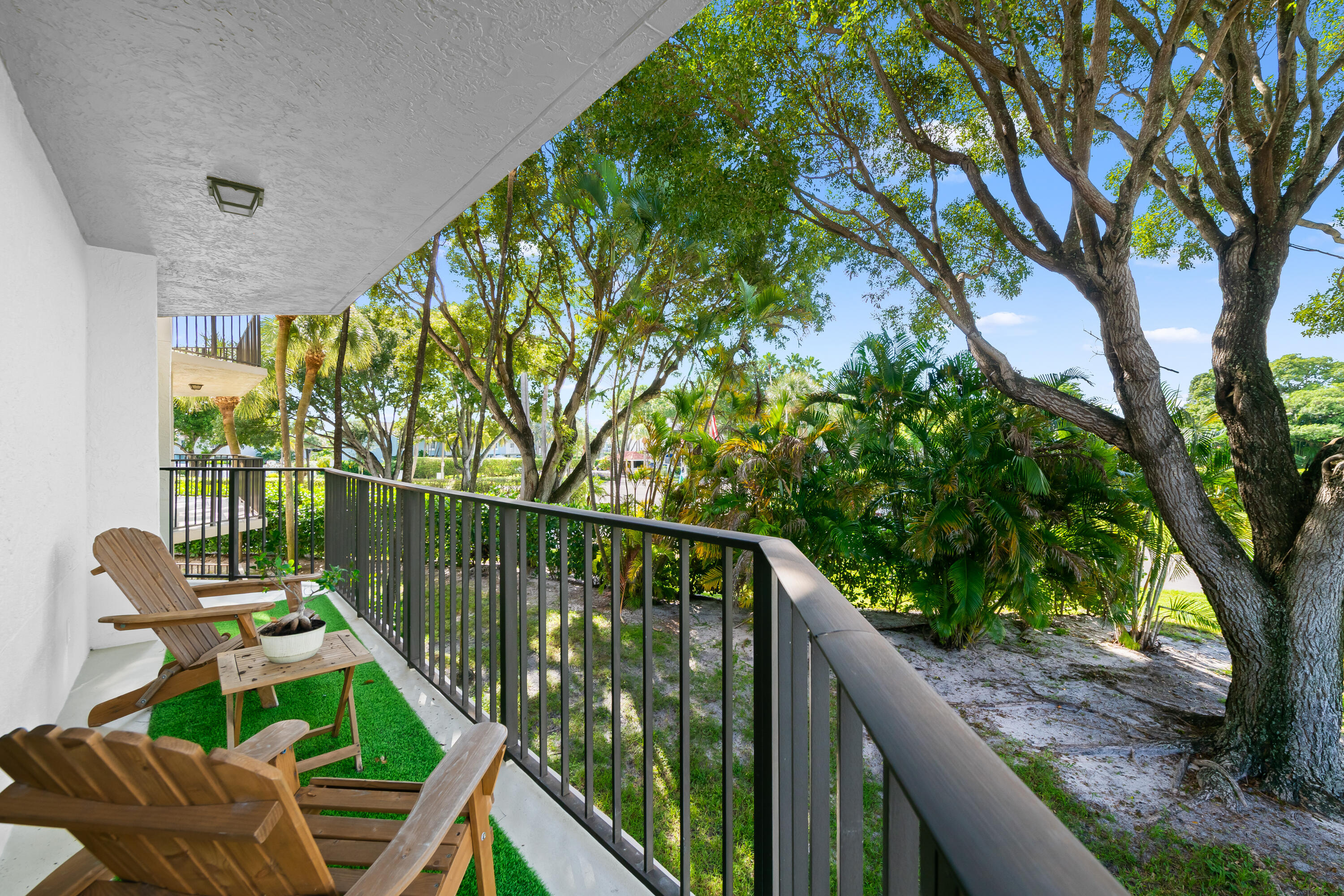799 Jeffery Street, Unit 202 Boca Raton, FL 33487 - Photo 22 of 39 a balcony with wooden floor table and chairs