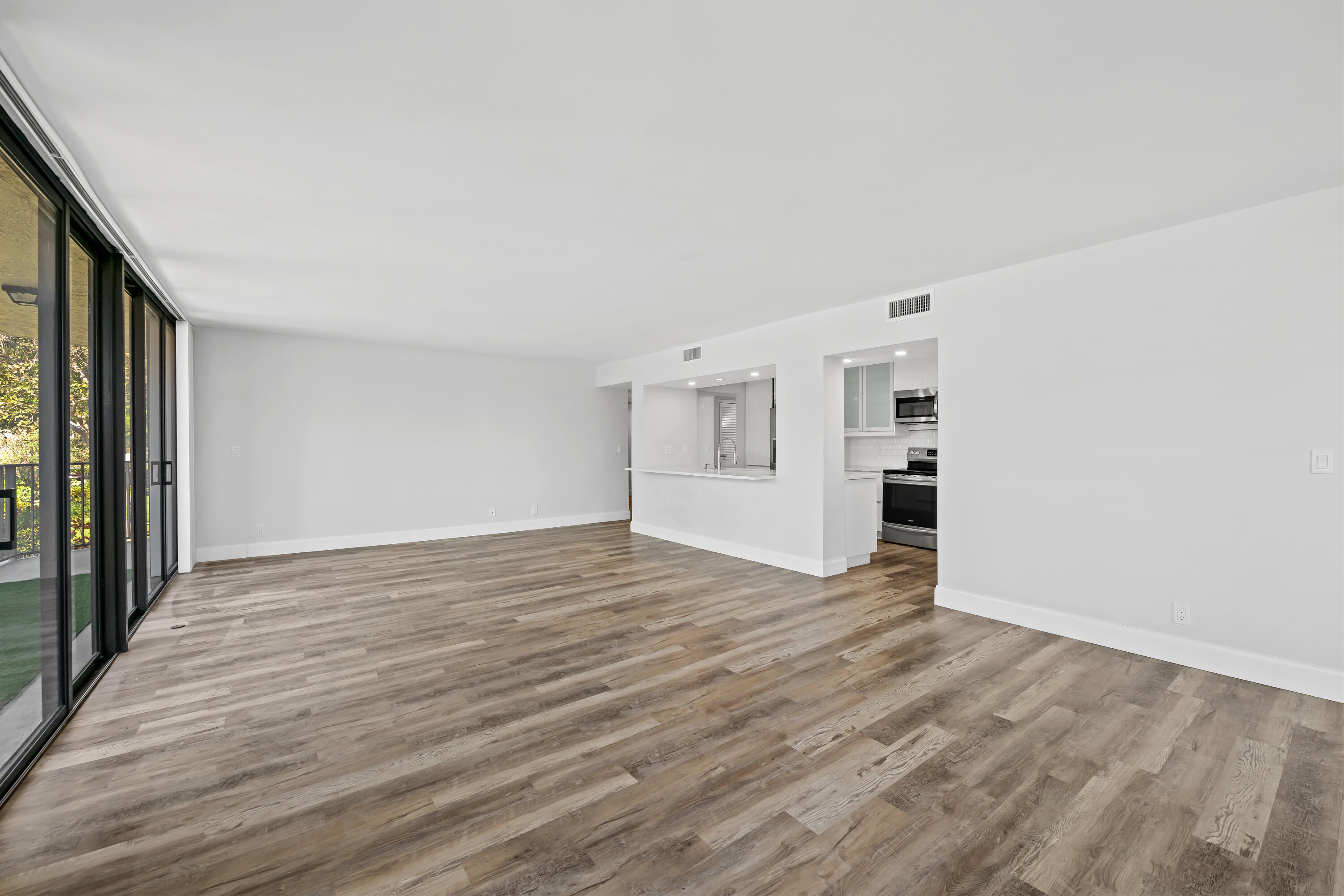 799 Jeffery Street, Unit 202 Boca Raton, FL 33487 - Photo 7 of 39 a view of empty room with wooden floor and kitchen