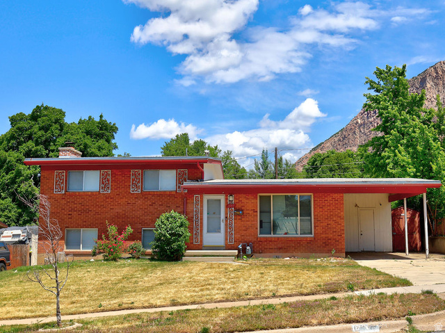 1272 Cook Street Ogden, UT 84404 - Photo 3 of 46 Red brick exterior with white trim, featuring a flat roofline and a front carport