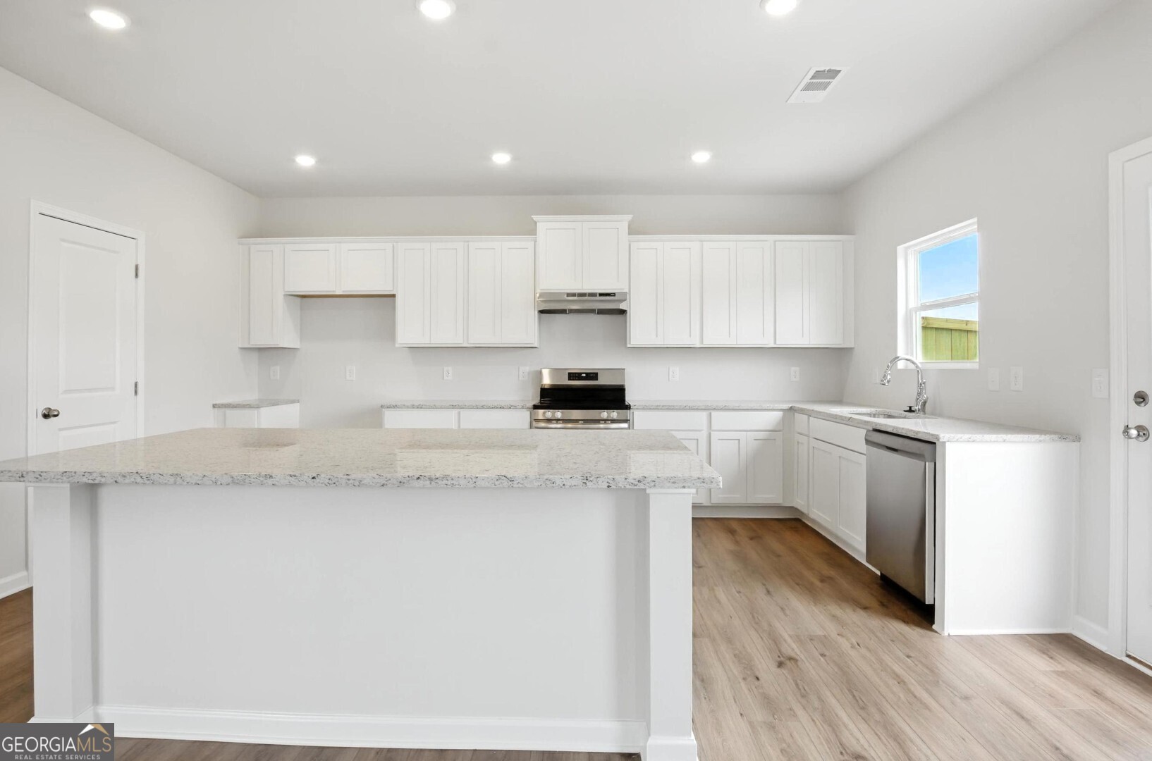 6 Umber Lane Newnan, GA 30263 - Photo 12 of 43 a kitchen with granite countertop white cabinets and white appliances