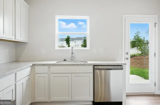 a kitchen with white cabinets and sink