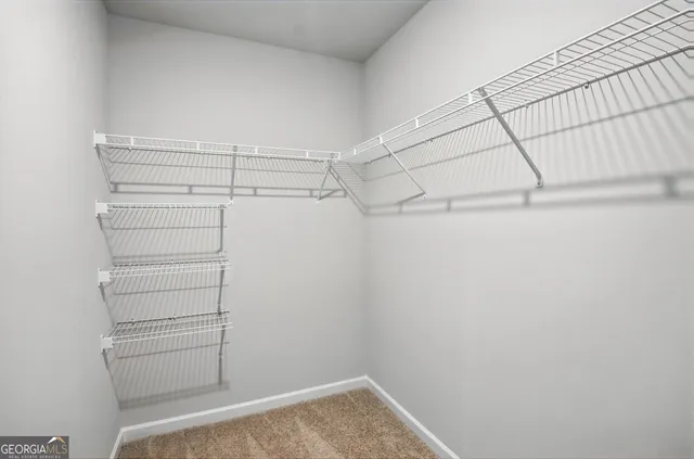 a view of walk in closet with empty racks