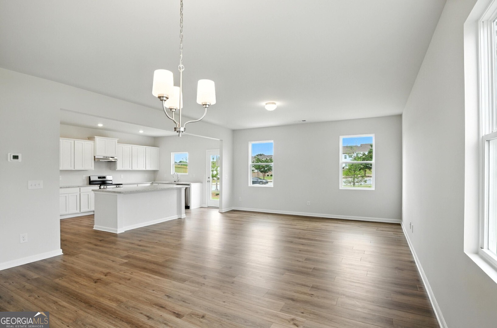 6 Umber Lane Newnan, GA 30263 - Photo 8 of 43 a view of kitchen with sink microwave refrigerator and stove with wooden floor