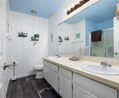 a bathroom with a granite countertop sink a toilet and a mirror