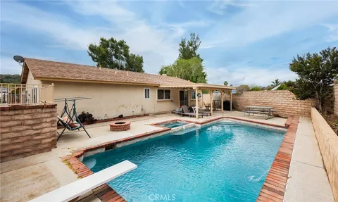 a view of a patio with table and chairs with wooden floor and fence
