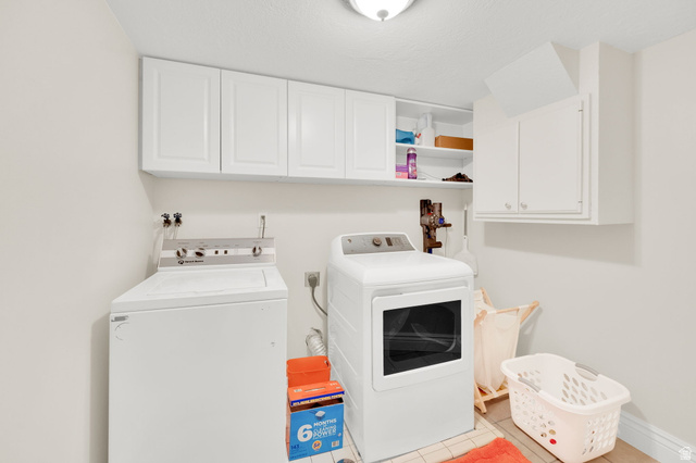1506 Lakeview Drive Bountiful, UT 84010 - Photo 31 of 58 Laundry room featuring cabinet space, washing machine and dryer, and light tile patterned floors