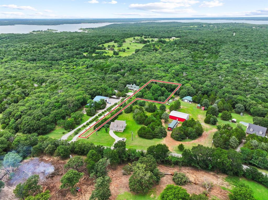207 Paradise Park Road Pottsboro, TX 75076 - Photo 8 of 28 Aerial perspective showcasing a property outlined in red, featuring a drive, mature trees, and proximity to a large body of water
