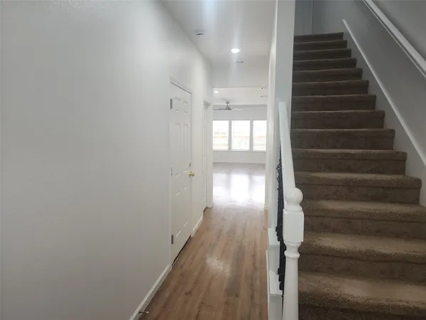 a view of entryway and hall with wooden floor