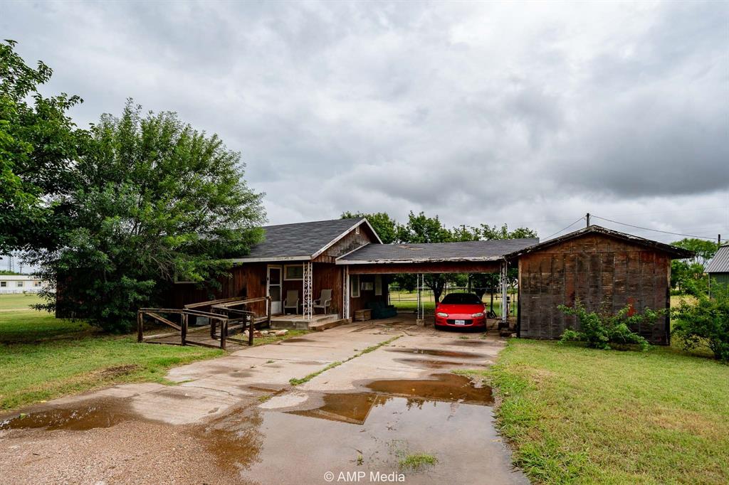 735 Northwest Ave F Hamlin, TX 79520 - Photo 1 of 18 a car parked in front of a house with wooden fence