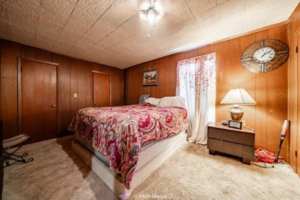 a bedroom with a bed and a lamp on the dresser