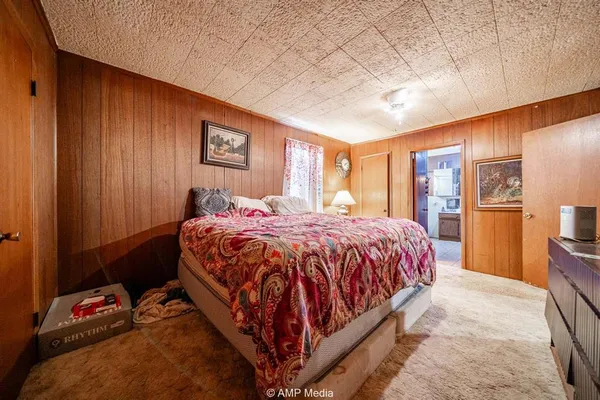 a bed sitting in a spacious bedroom next to a window