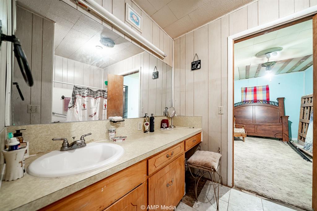 735 Northwest Ave F Hamlin, TX 79520 - Photo 15 of 18 a en suite bathroom with double vanity and a mirror