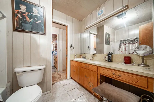 a bathroom with a granite countertop sink mirror vanity and toilet