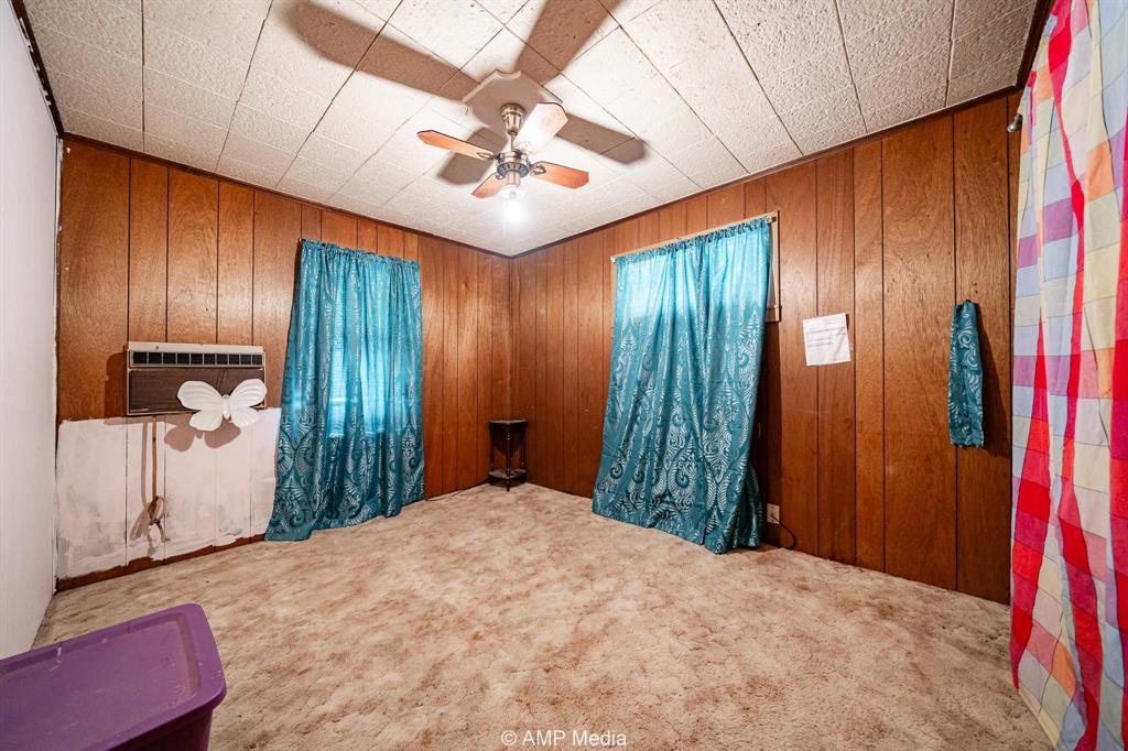 735 Northwest Ave F Hamlin, TX 79520 - Photo 18 of 18 a bedroom with a large bed and a chandelier