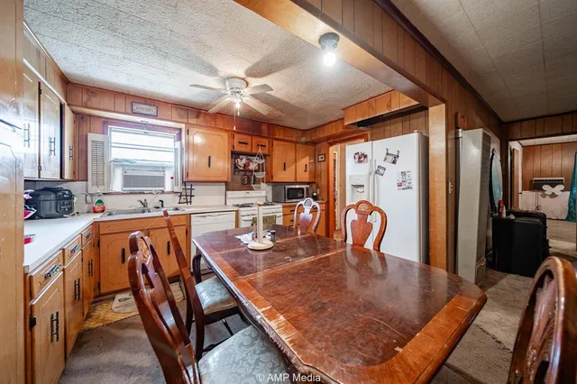 a dining room with stainless steel appliances granite countertop a dining table and chairs with the granite countertops