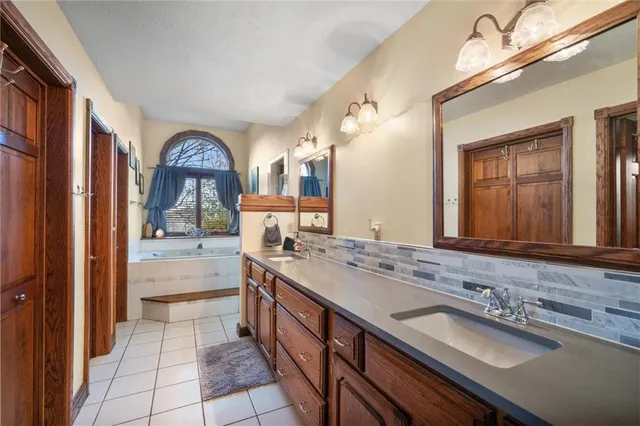 a spacious bathroom with a granite countertop sink and a mirror
