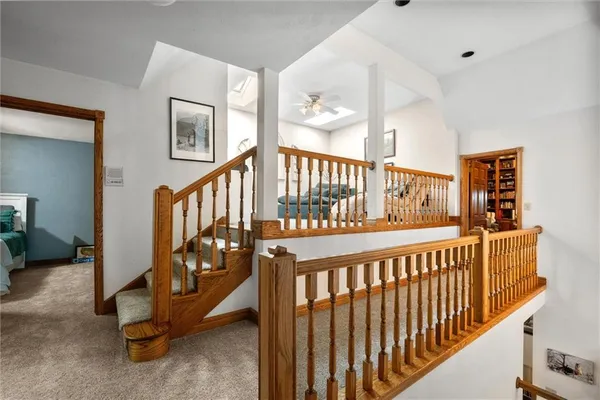 a view of staircase with lots of frames on wall
