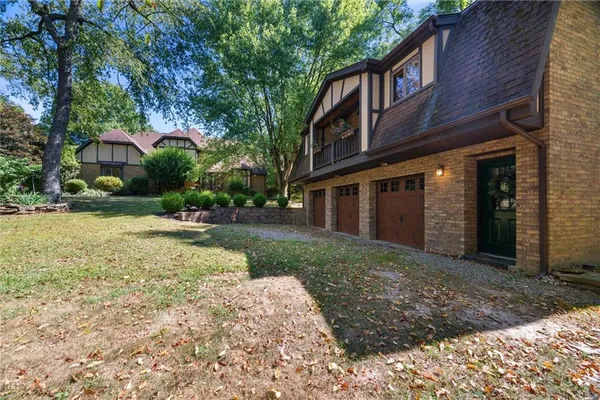 a view of a house with a yard and large tree