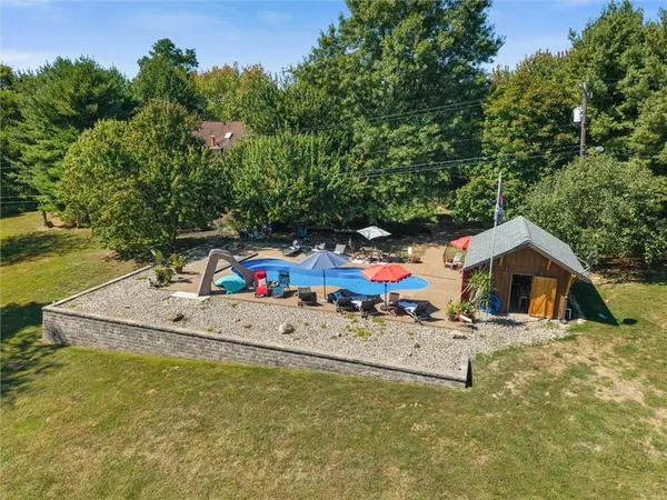 a small pool with lawn chairs and a small yard