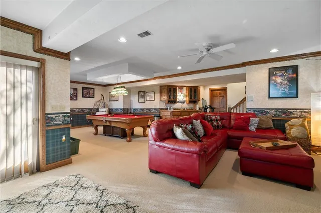 a living room with furniture kitchen view and a window