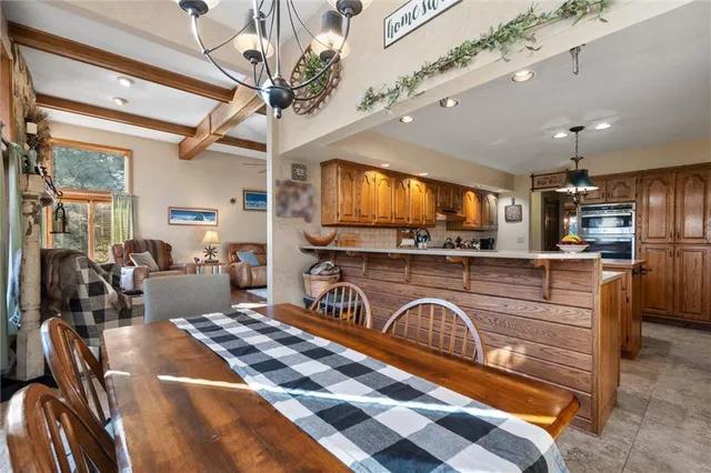 a kitchen with stainless steel appliances granite countertop a stove a sink dishwasher a dining table and chairs with wooden floor