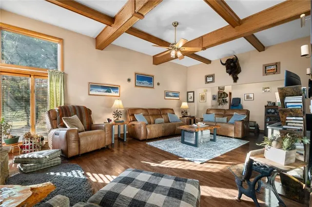 a living room with furniture a chandelier and a large window